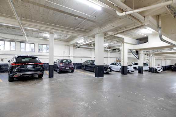 A parking garage with several cars parked.