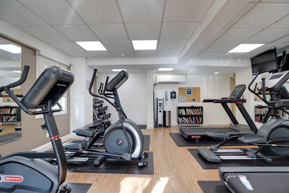 A gym with treadmills and elliptical machines.