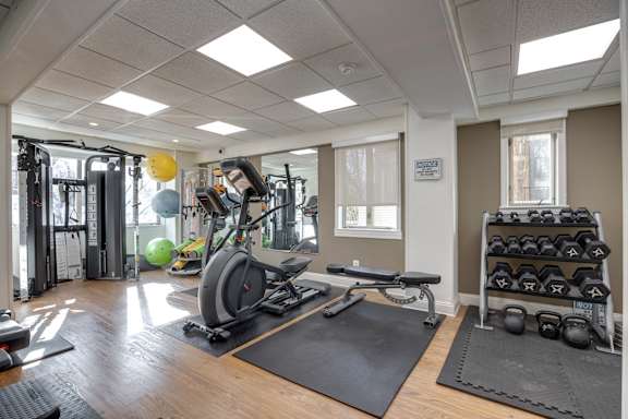 A gym with a variety of equipment including weights and a treadmill.