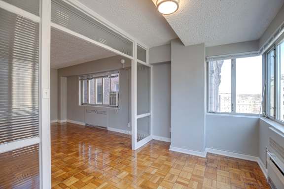 A room with wooden flooring and white walls.