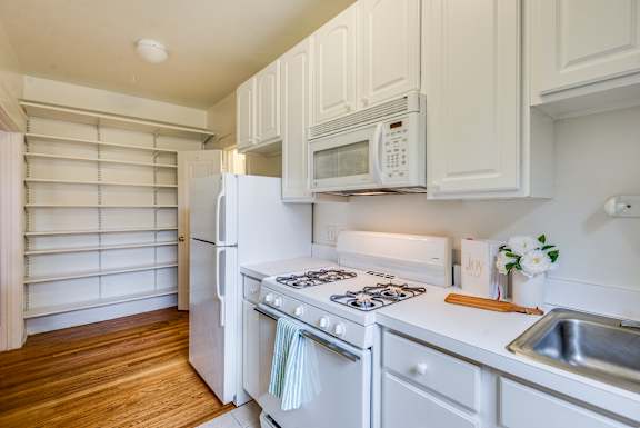 Gas range cooking and microwave at 4115 Wisconsin Avenue Apartments in Washington, DC  20016