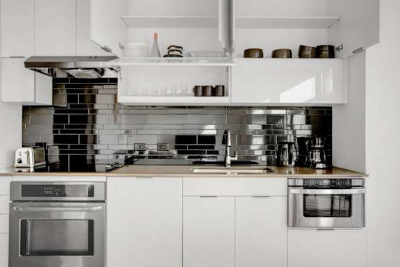 A modern kitchen with stainless steel appliances and white cabinetry. at The Shay, Washington, 20001