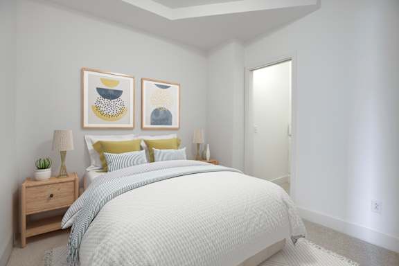 A bedroom with a bed, nightstand, and two framed pictures on the wall.