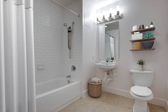 A white bathroom with a toilet, sink, and bathtub.