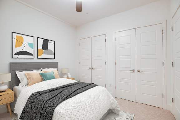 A bedroom with a bed, nightstand, and two framed pictures on the wall.