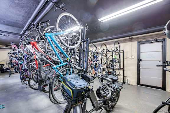 A bike is parked in a garage with a blue handle bar.