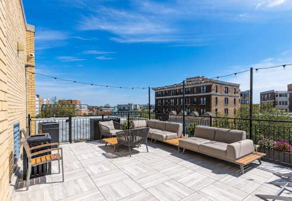 A rooftop patio with a table and chairs.