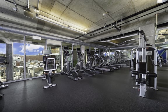 a spacious fitness center with cardio equipment and a view of the city at The Shay, Washington