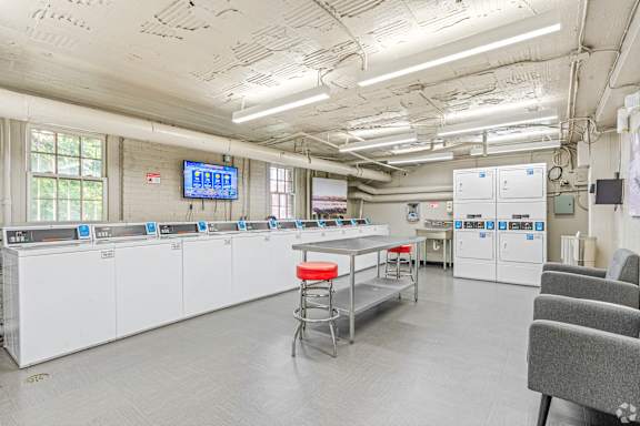 A large industrial kitchen with white cabinets and stainless steel appliances.