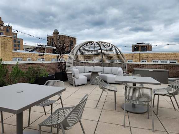 A patio with a table, chairs and a canopy.