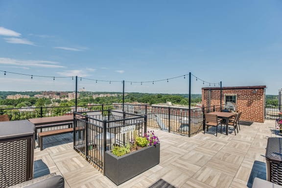 a roof deck with tables and chairs and a view of the city