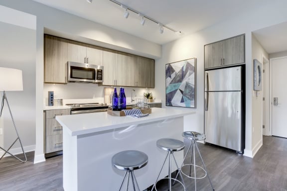 A kitchen with a white counter top and stainless steel appliances at Valo Apartments, District of Columbia