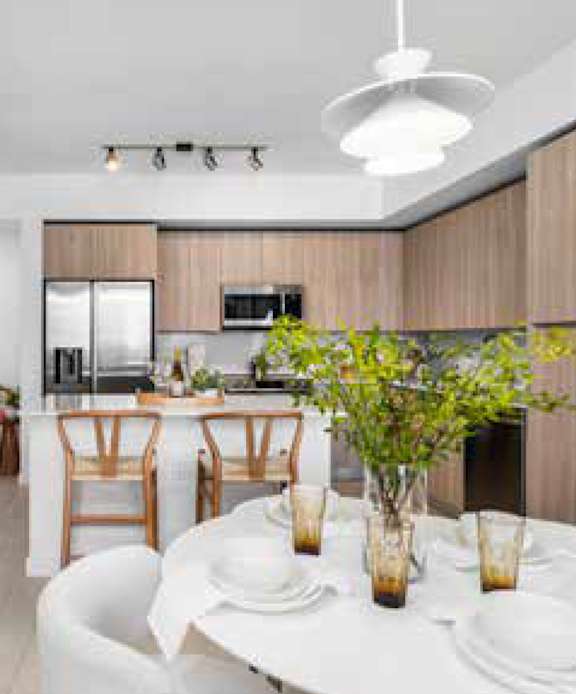 A modern kitchen with a dining table set for two.