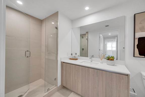 A modern bathroom with a walk-in shower and double sink vanity.