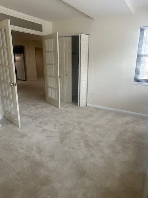 A room with a carpeted floor and a white door.