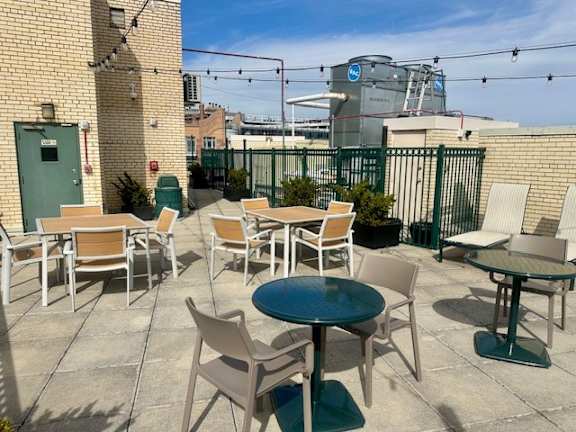 A patio with a table and chairs is set up on a rooftop. at 2400 Pennsylvania Avenue Apartments, Washington, DC,20037