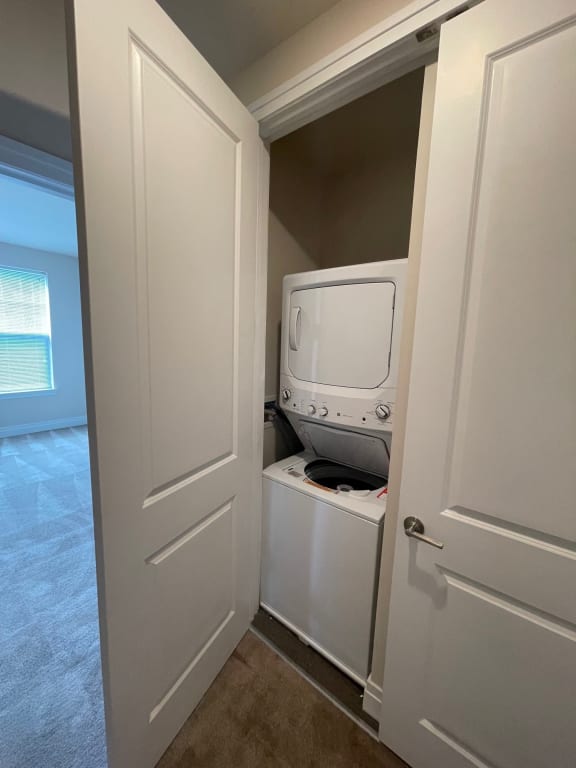 walk through closet with stackable washer and dryer