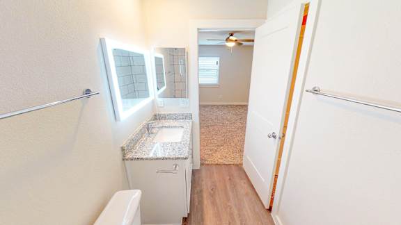 A small bathroom with a toilet, sink, and mirror.