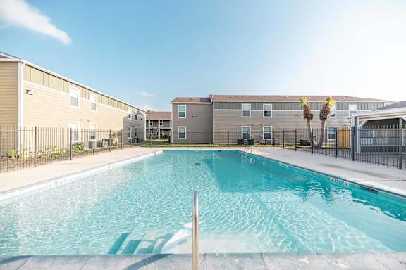 A swimming pool in front of apartment buildings.