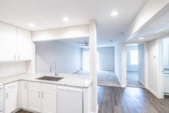 A kitchen with white cabinets and a sink.