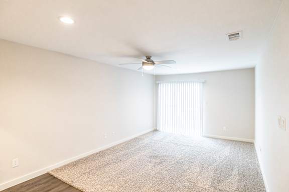 A room with a ceiling fan and a carpeted floor.