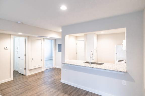 A modern kitchen with a sink and a large mirror.