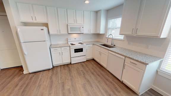 A kitchen with white appliances and cabinets.