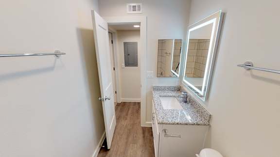 A bathroom with a sink, mirror, and toilet.