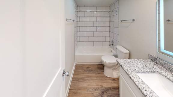 A white bathroom with a toilet, sink, and bathtub.