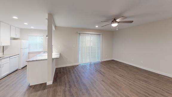 A room with a ceiling fan and a window with blinds.