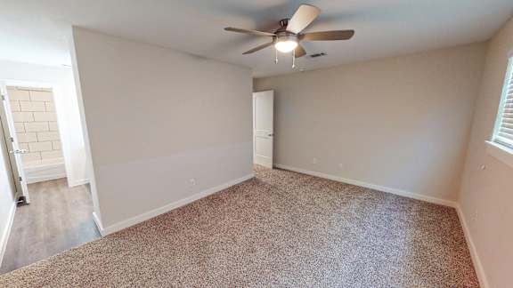 Primary Bedroom with a ceiling fan and carpeted floor.