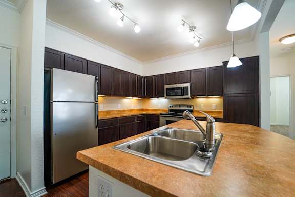 A kitchen with a stainless steel refrigerator and a wooden countertop.