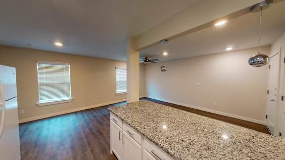 A kitchen with a granite countertop and a ceiling fan.