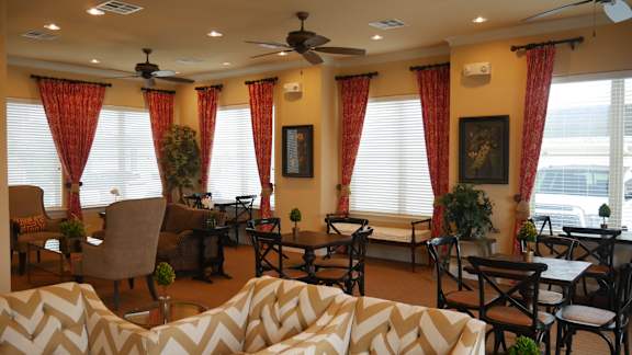 A living room with a white sofa and a ceiling fan.