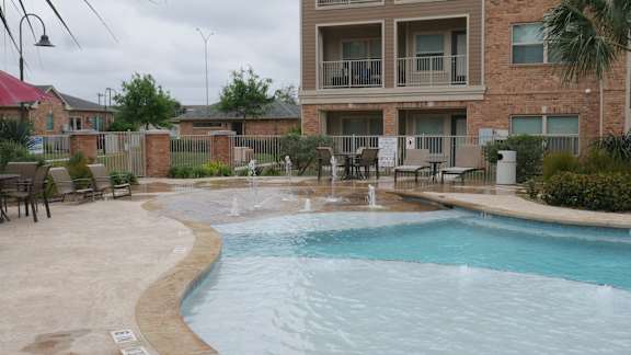 A pool with a fountain in the middle of it.