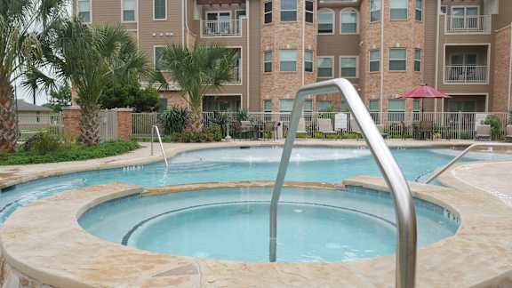 A large outdoor swimming pool with a slide.