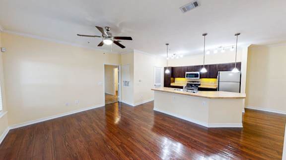 A room with a wooden floor and a ceiling fan.