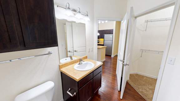 A bathroom with a sink, mirror, and toilet.