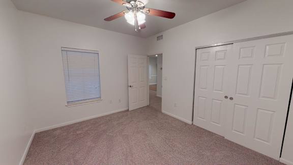 A room with a ceiling fan and two doors.
