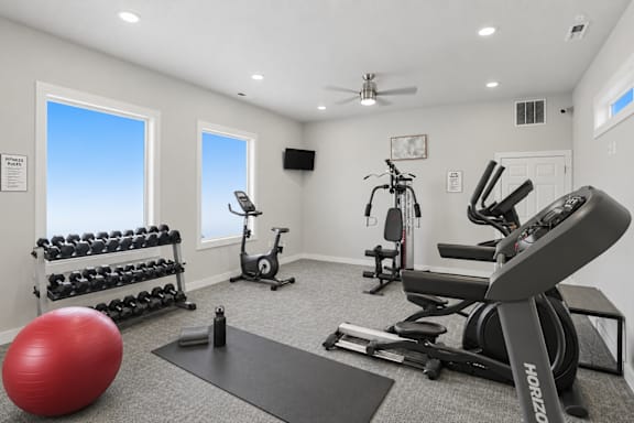 Home gym with equipment and workout mat at Park Station Apartments, Midvale