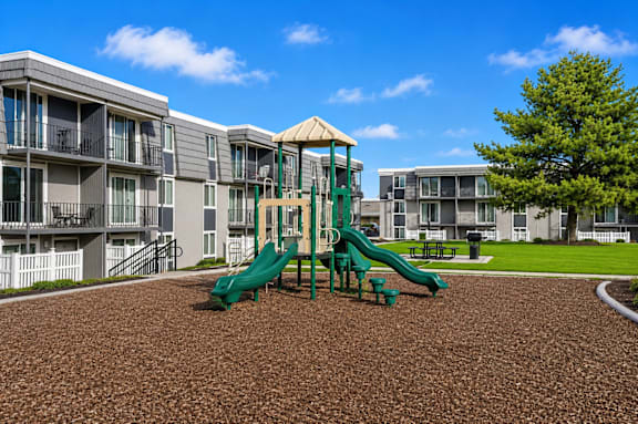 Playground with slides on mulch surface at Park Station Apartments, Midvale, UT 84047