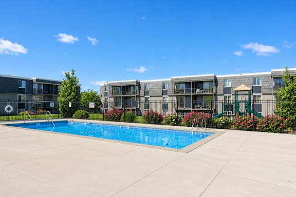 Swimming pool with surrounding deck and apartments at Park Station Apartments, Midvale, UT