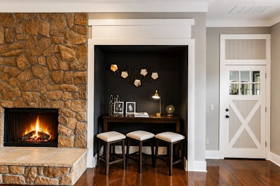 A cozy room with a stone fireplace and a wooden table.