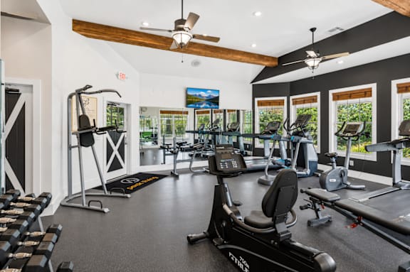 A gym with a variety of equipment including treadmills, stationary bikes, and weight machines.