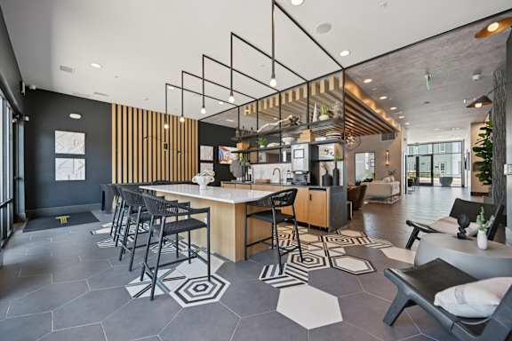 Community clubhouse with kitchen island and lounge seating at Sequel Homes Apartments, Englewood