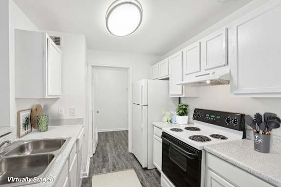 A kitchen with white cabinets and a black stove top oven.