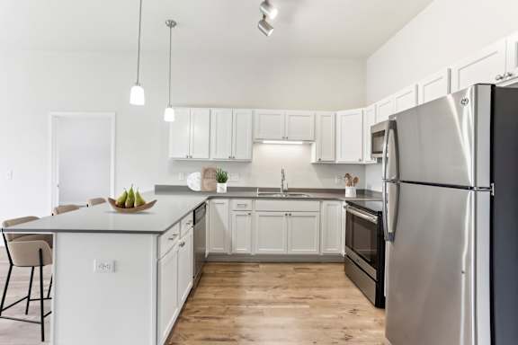 A modern kitchen with a large island and stainless steel appliances.