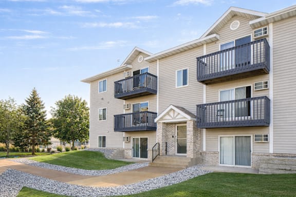Three story apartment building with balconies and entrance at Prosper West Apartments, Waite Park, MN 56387