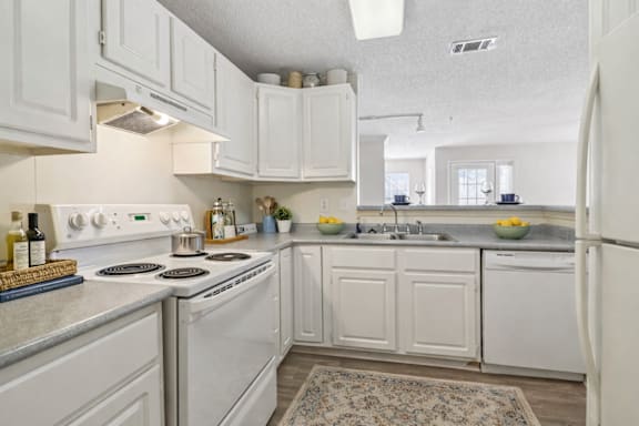 A kitchen with white cabinets and appliances.
