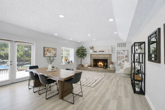 A modern dining room with a fireplace and a large table.